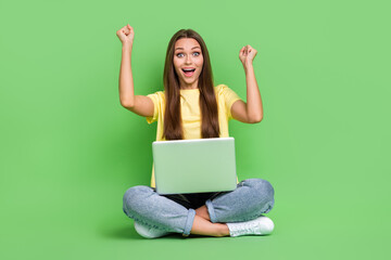 Photo of astonished positive stylish lady raise hand fist rejoice pass online exam shout hooray yes isolated on green color background