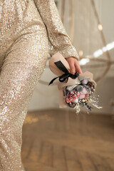 Girl in shiny trousers holding Bouquet of dried flowers for a gift in the new year