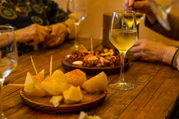 Tapa de pulpo con patatas y una copa de vino. 