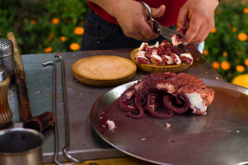 Preparación de una tapa de pulpo. Hombre prepara una tapa de pulpo.