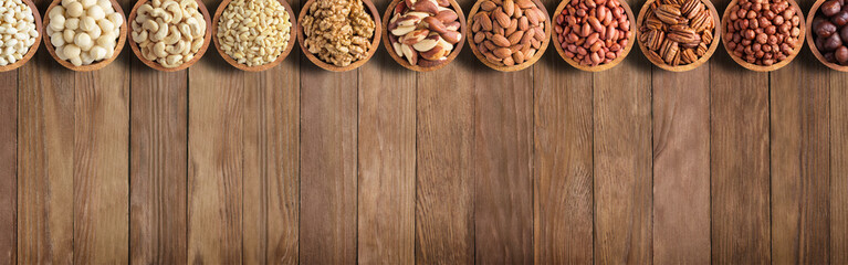 assorted nuts and seeds on rustic table, organic food background with empty space