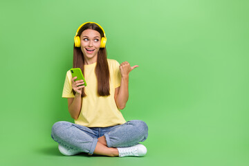Photo of positive lady wear yellow clothes accessory sit finger point empty space offer devise shop...