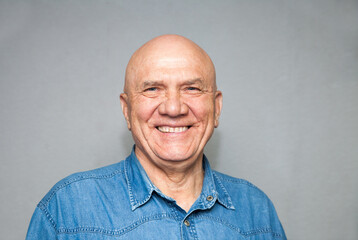Mature man wearing  denim shirt  on grey background