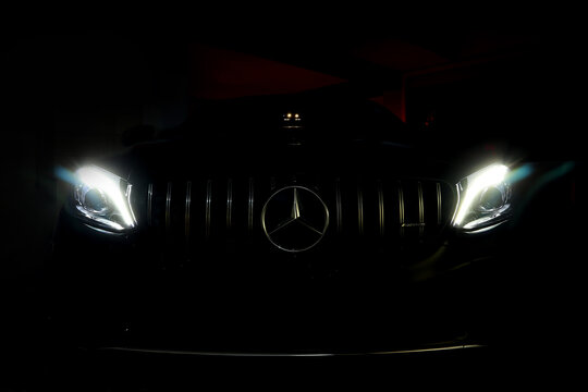 Mercedes Benz chromium grille with Benz star and amg logo with led headlight of black c class c200 coupe AMG model in the dark garage during maintainance checking service