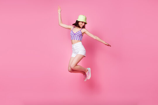 Full size photo of cheerful lady tourist jumping high hands aside isolated pastel color background