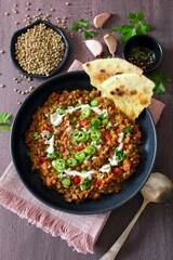 Lentil with vegetables served with sream and naan bread. Top view. Vegetarian and vegan food.