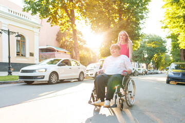 Young female caregiver pushing wheelchair with female person with disability across city street