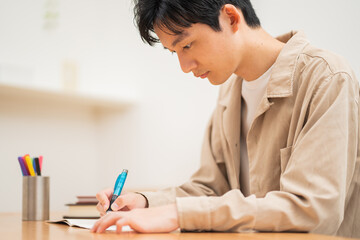 自宅で勉強する若い日本人男性
