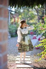 A beautiful woman in lolita dress in garden background Japanese street fashion portrait