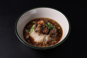 Braised pork noodles Thai street food isolated in black background