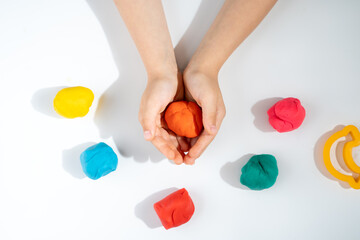 children's hands with plasticine, the development of fine motor skills and speech in children, top view, on a white background