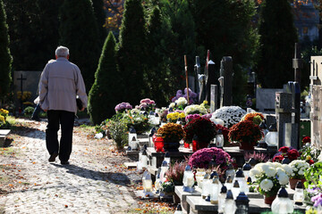 Polski cmentarz w czasie święta zmarłych odwiedzają starsi ludzie. - obrazy, fototapety, plakaty