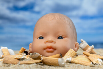 A baby doll with cigarettes on beach