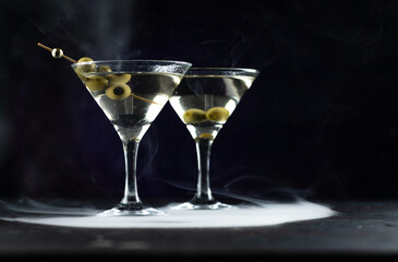 A martini in a triangular glass with olives is on the table