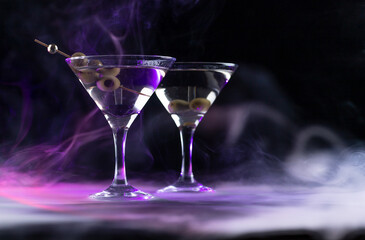 A martini in a triangular glass with olives is on the table