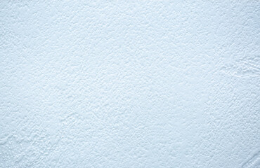 Blue background of decorative plaster with abstract spots. Unusual texture of this wall with beautiful patterns, creative surface background. Finishing coating for building cladding.