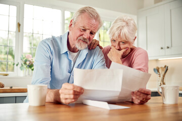 Worried Retired Senior Couple Looking At Bills At Home Concerned About Cost Of Living