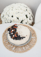 Beautiful cake with berries. Cake smeared with white cream and decorated with blueberries, figs, marshmallows and chocolate truffles