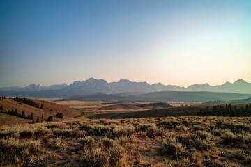 The Sawtooth Mountain Range seen from the foothills north of Stanley, Idaho on a summer evening. The sky is hazy due to forest fire smoke.