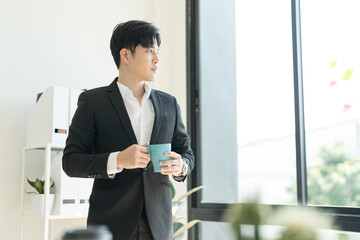 Businessman drinking coffee to increase active and use a laptop to find information For the success.