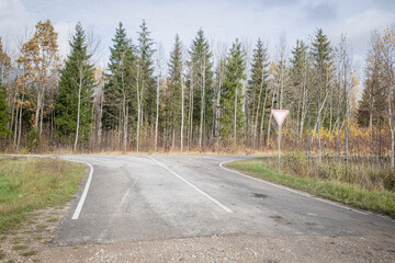 Obraz premium The sign Give way to the driver when exiting the highway at a rural intersection on the background