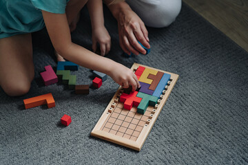 Board puzzle game. Mom with Child playing a Board game. Educational games for children. Development of spatial thinking in kids.