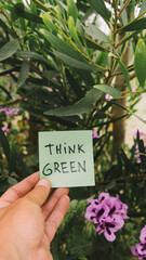 small sign written think green among the plants defending the environment and the planet