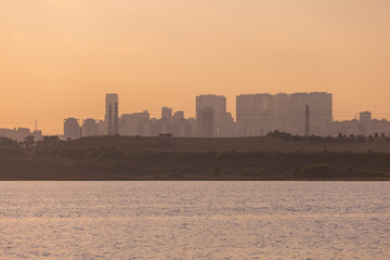 Naklejka premium Orange sunset sky and sun over the sea. Silhouette of the city of Istanbul on the horizon.