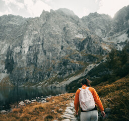 Fototapeta premium A beautiful brunette woman is hiking in the mountains of Europe. Young girl relaxing in the Tatra Mountains. Concept of a healthy active life outdoor