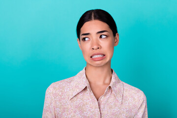 Photo of unsatisfied malaysian girl grin teeth look curious empty space isolated on emerald color...