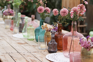 Beautiful decoration with flowers and colorful glass vases