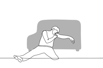 man sits on the floor leaning on a sofa - one line drawing vector. concept fatigue
