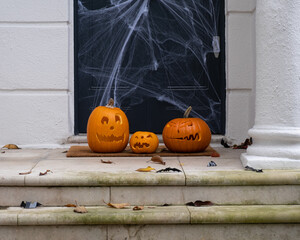 Halloween decorations of traditional english house. Funny carved pumpkins on the doorstep.