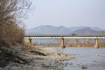 Fototapeta premium TUMEN, JILIN PROVINCE, CHINA - April 2008: black limousine crossing road bridge from Namyang (North Korea), over Tumen river, Yanbian Korean Autonomous Prefecture