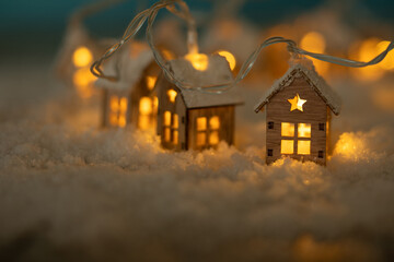 Abstract Christmas Winter Greeting Card with Wooden Houses Christmas String Lights in Cold Snow...