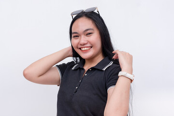 A cheerful Filipino woman with strong long hair in her early 20s. Wearing a black polo shirt. Isolated on a white background.