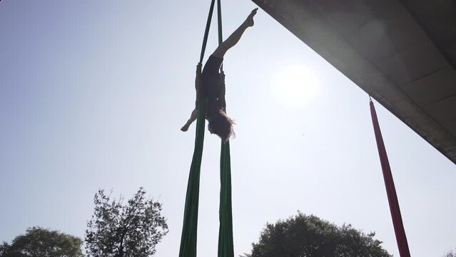 Spanish woman doing acrobatics high under a bridge in a park