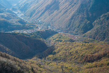上から見た紅葉に彩られた山と町の風景