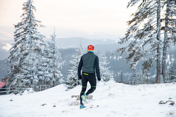 Fototapeta na wymiar trail runner with frozen beard training in winter landscape