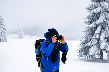 Fototapeta na wymiar man trekking in magical frozen winter landscape with snow covered fir trees