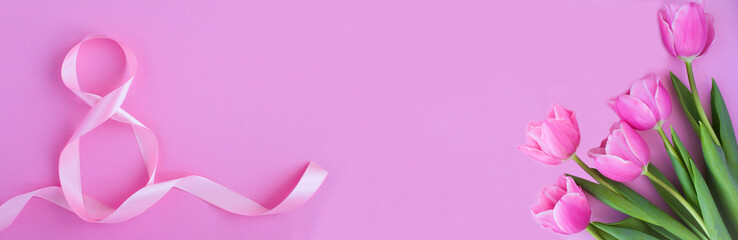 Holiday banner. Pink number eight ribbon and pink tulips on the pink background. Top view. Copy space.