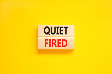 Quiet fired symbol. Concept words Quiet fired on wooden blocks. Beautiful yellow table yellow background. Business and quiet fired concept. Copy space.