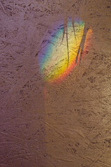 Bright rainbow light spot and shadows on textured plywood surface close view. Wonderful effect and...