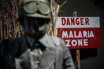 Danger sign used during the Second World War in malaria disinfestation areas - Next to a man in...