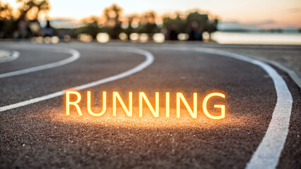 The word running on an asphalt running track in a park near a lake