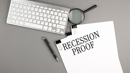 RECESSION PROOF text on paper with keyboard, magnifier and pen. Business concept