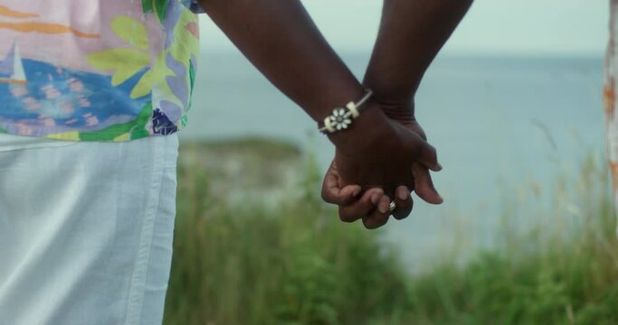 CU Mature couple holding hands on coast