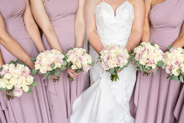 Obraz na płótnie Canvas Bride and bridesmaids holding bouquets 
