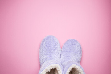 Soft blue homemade ugg boots on a pink background.