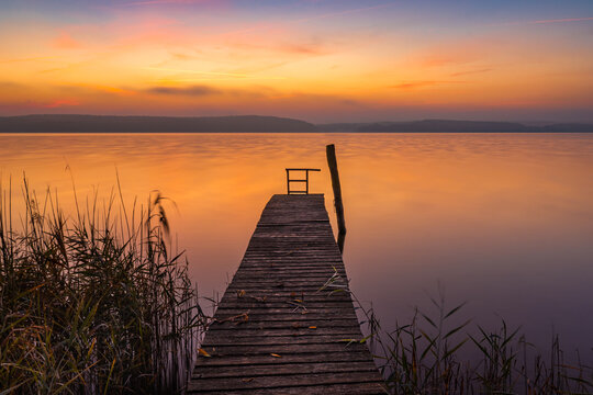 Sonnenaufgang über einem Bootssteg am Ufer des Plauer Sees in Plau am See in der Mecklenburgischen Seenplatte